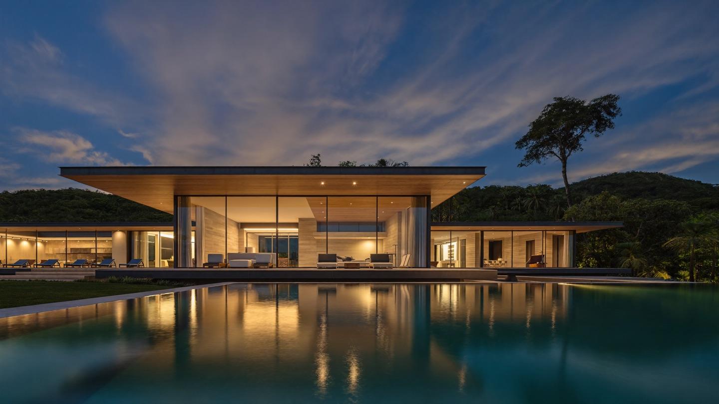 Casa de alto padrão ao anoitecer com iluminação automatizada e piscina