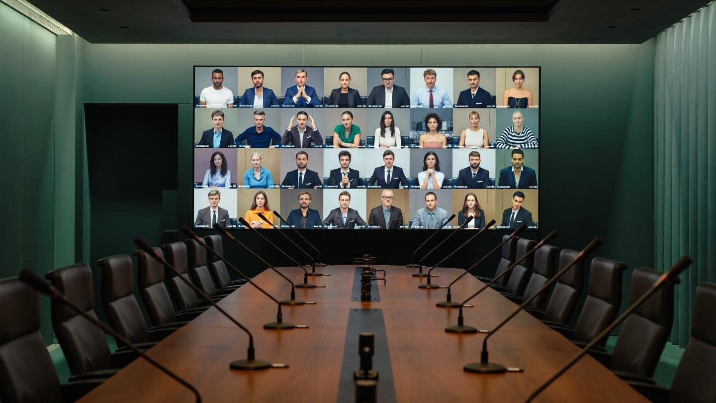 Sala executiva de videoconferência com video wall e microfones de mesa